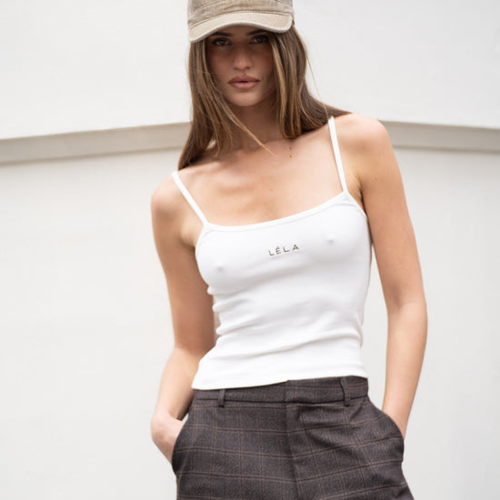 Full-length view of washed army green LÉLA cap paired with white LÉLA tank top and brown LÉLA Archer trousers against white background