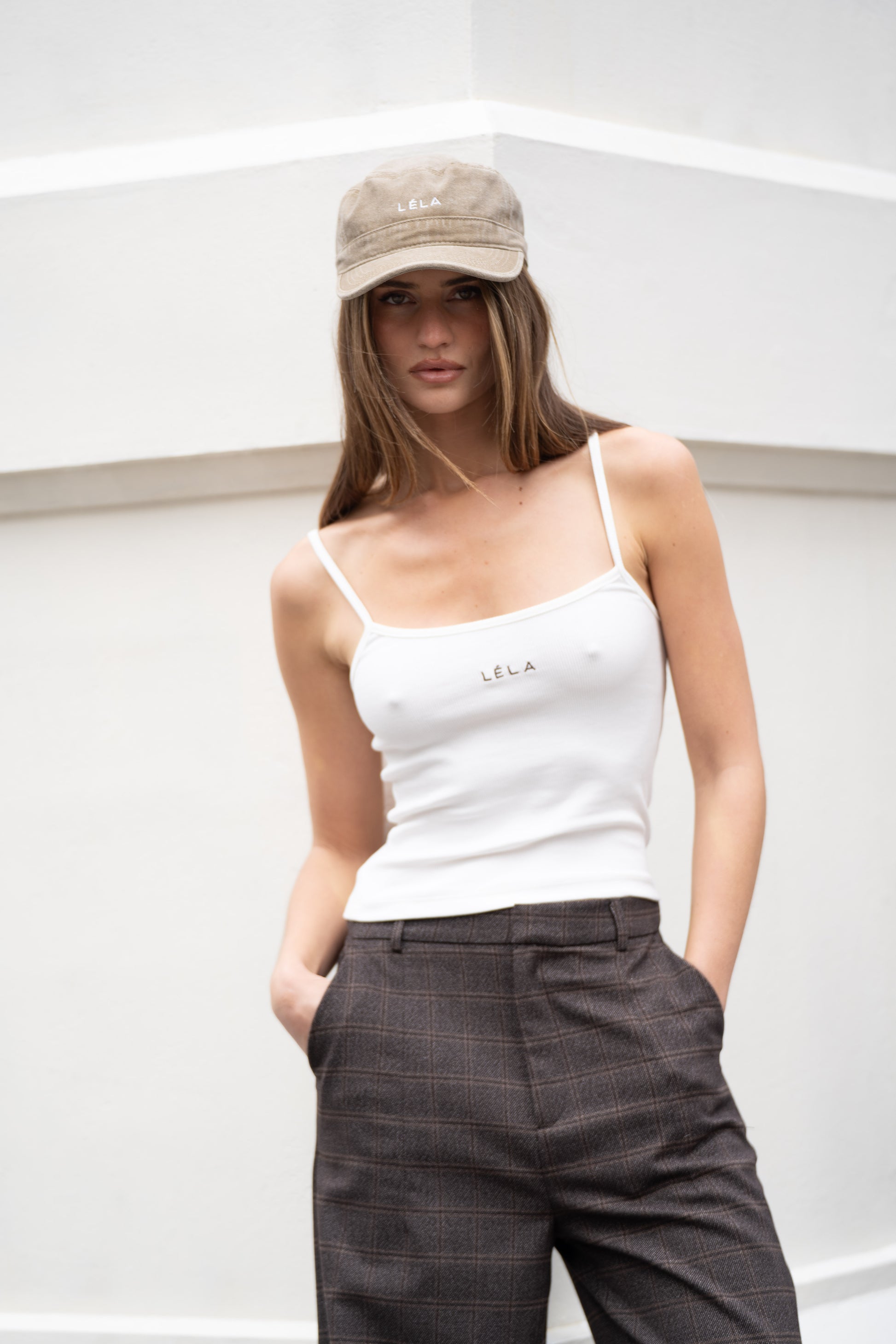 Full-length view of washed army green LÉLA cap paired with white LÉLA tank top and brown LÉLA Archer trousers against white background