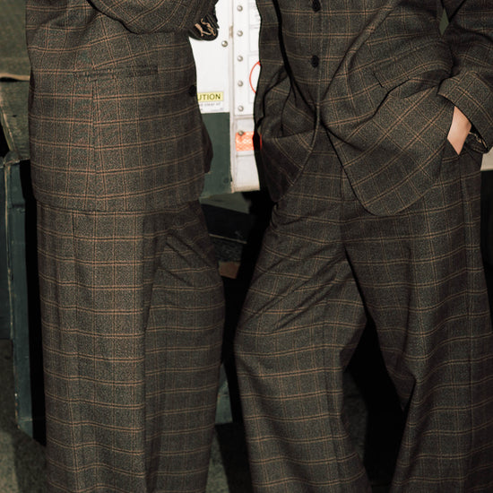Close-up detail of brown windowpane plaid Carter Blazer and matching pants showing windowpane check pattern, styled with white t-shirt