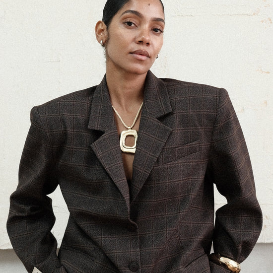 Model wearing brown windowpane plaid Archer Blazer with matching pants, paired with gold necklace in front of white background