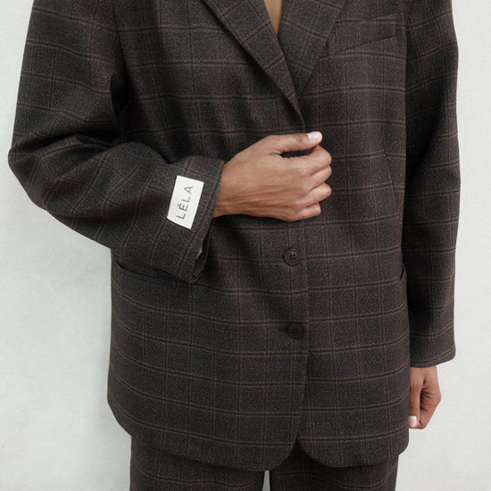 Close-up of brown windowpane plaid Archer Blazer showing tailored construction and windowpane check pattern, styled with matching pants and three-button closure