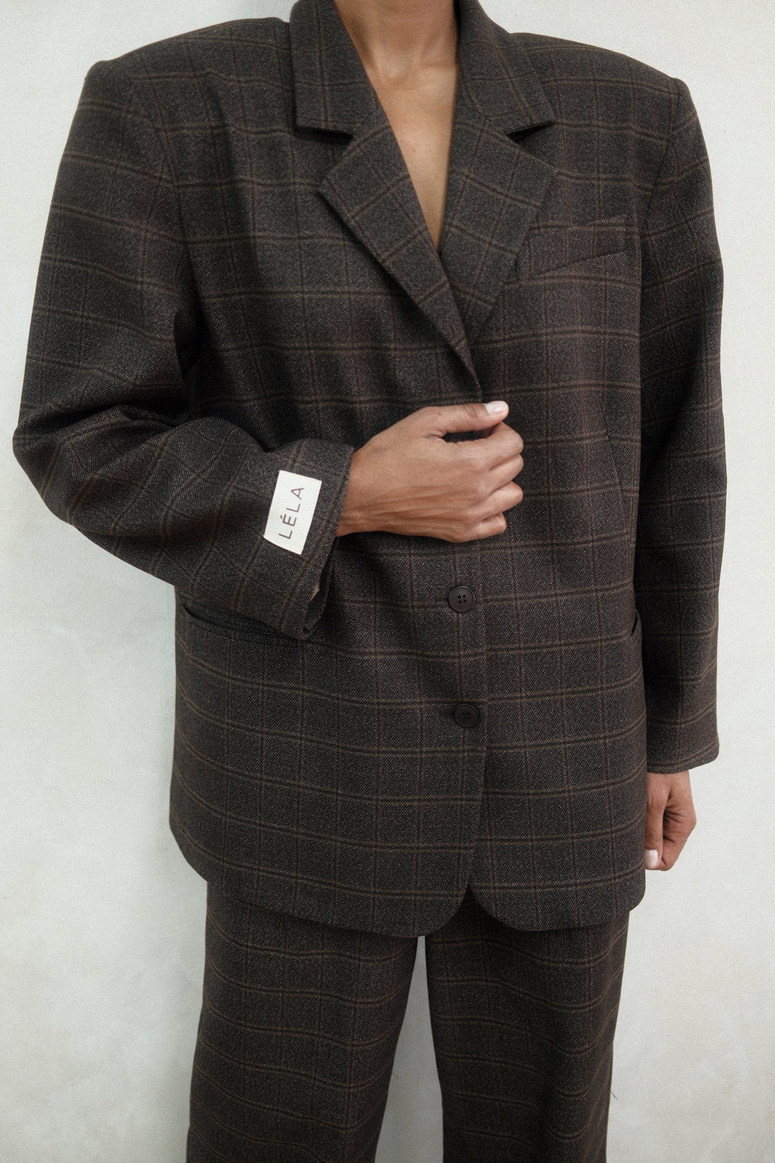 Close-up of brown windowpane plaid Archer Blazer showing tailored construction and windowpane check pattern, styled with matching pants and three-button closure