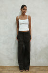 Front view of model wearing brown windowpane plaid Carter Pants with white LÉLA tank top, showing high-waisted wide-leg fit against white background