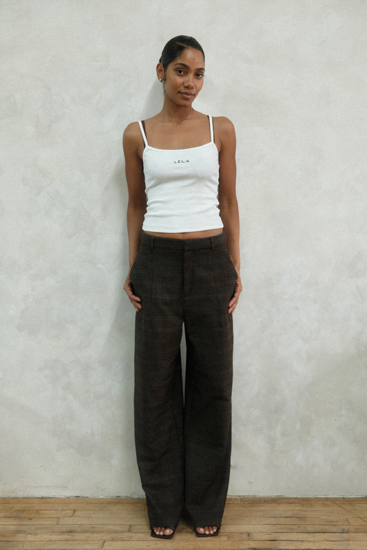 Front view of model wearing brown windowpane plaid Carter Pants with white LÉLA tank top, showing high-waisted wide-leg fit against white background