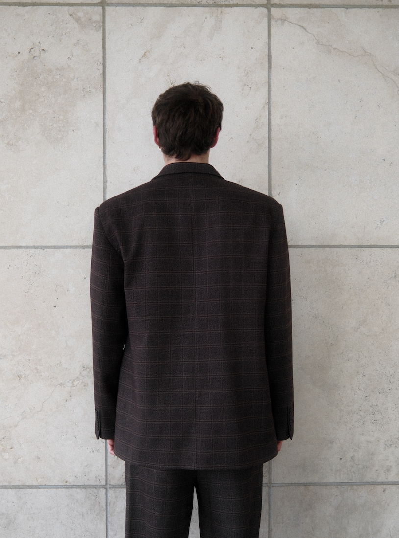 Back view of brown windowpane plaid Archer Blazer showing tailored construction and windowpane check pattern, styled with matching pants on male model